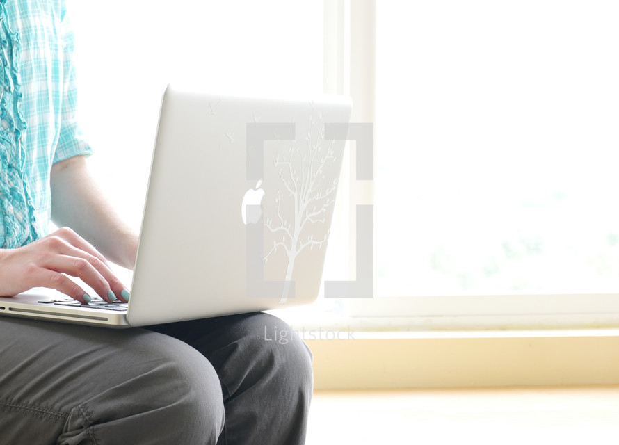teen girl behind a laptop screen 