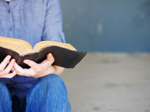 a man sitting reading a Bible 