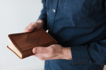 a man holding a Leather Bible 