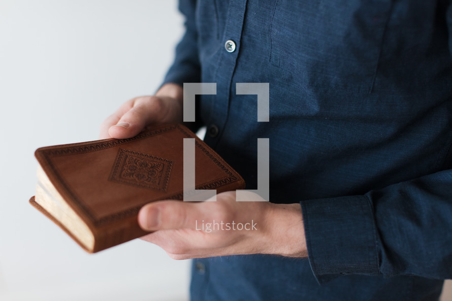 a man holding a Leather Bible 