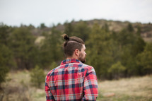 man in a plaid shirt with his back to the camera 