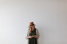 a woman standing reading a Bible 