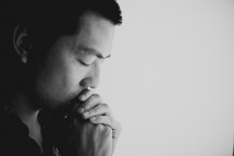 A young Asian man praying
