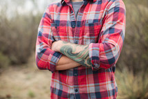man in a plaid shirt with arms folded across his chest 