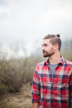 side profile of a man in a plaid shirt 
