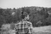man in a plaid shirt with his back to the camera 