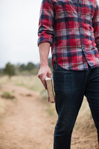 man in a plaid shirt holding a Bible 