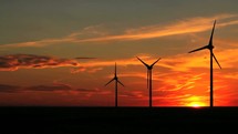 Wind turbines blowing at sunset.