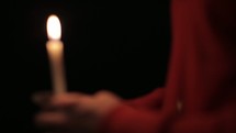 A man holding a flickering candle