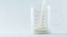 powder being poured into a measuring cup 