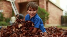 child playing in leaves 