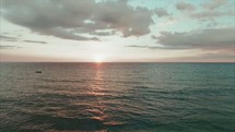 drone shot over the ocean at sunset 