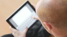 A man typing on his iPad 