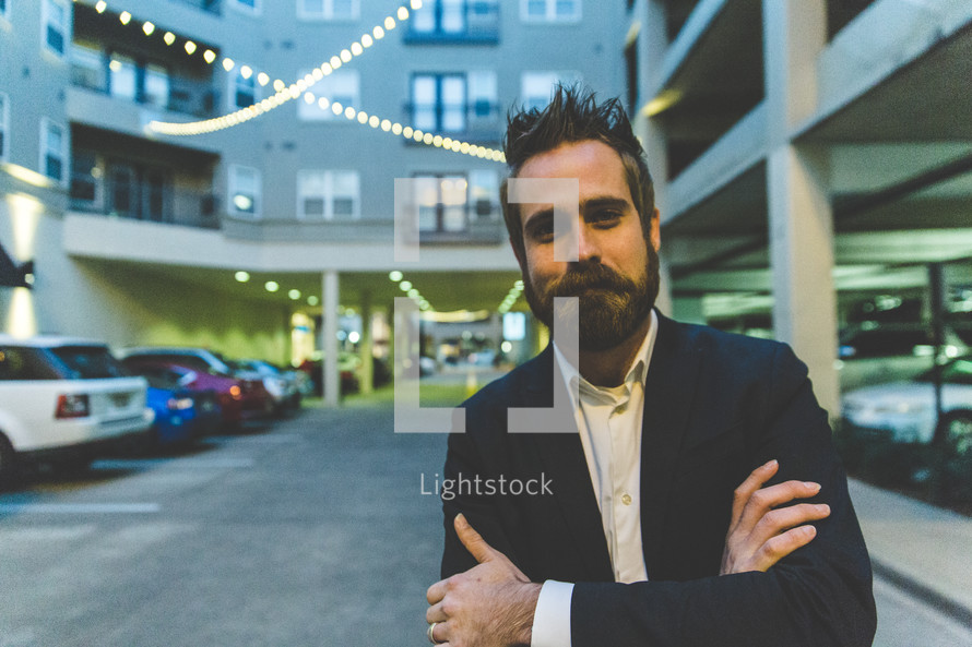 man in a blazer posing in a parking garage