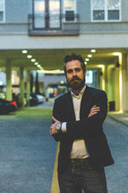 man in a blazer posing in a parking garage 