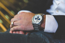 man wearing a wrist watch and wedding ring 
