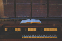 Bible and piano in a window sill 