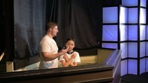 man baptizing a child 