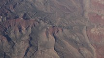 Aerial view of mountains and valleys as seen from a plane flying overhead.