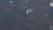 Aerial view of the earth and clouds as seen from a plane flying overhead.