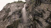 woman by a waterfall over a cliff 