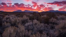 Timelapse of a fiery mountain sunset over a field of sagebrush.   This time-lapse was filmed near Mono Lake, California.