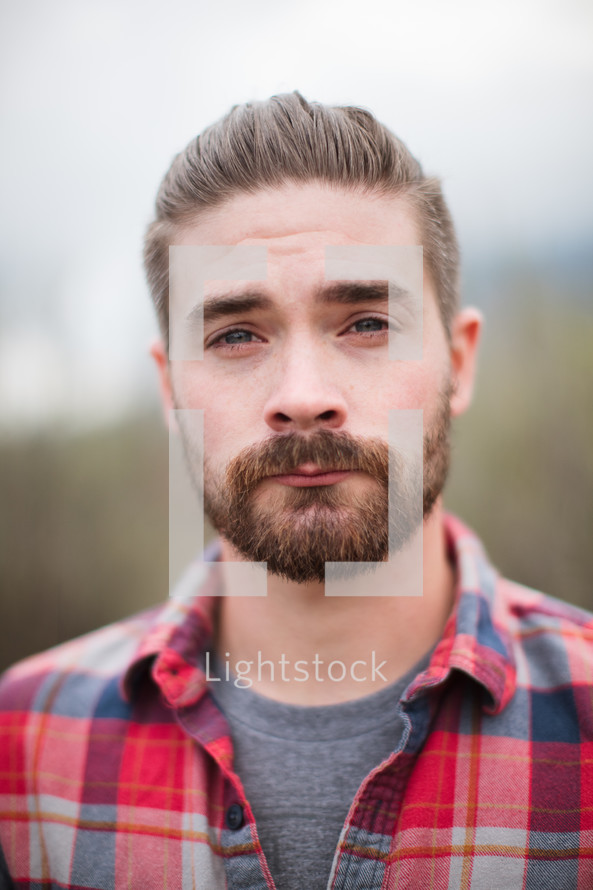 head shot of a man in a plaid shirt 