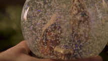 Woman placing a snow globe on a table.