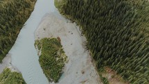 aerial view over a river through a forest 