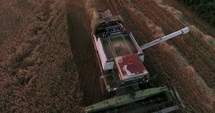 combine plowing over a field 
