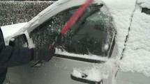 Cleaning snow off a car.