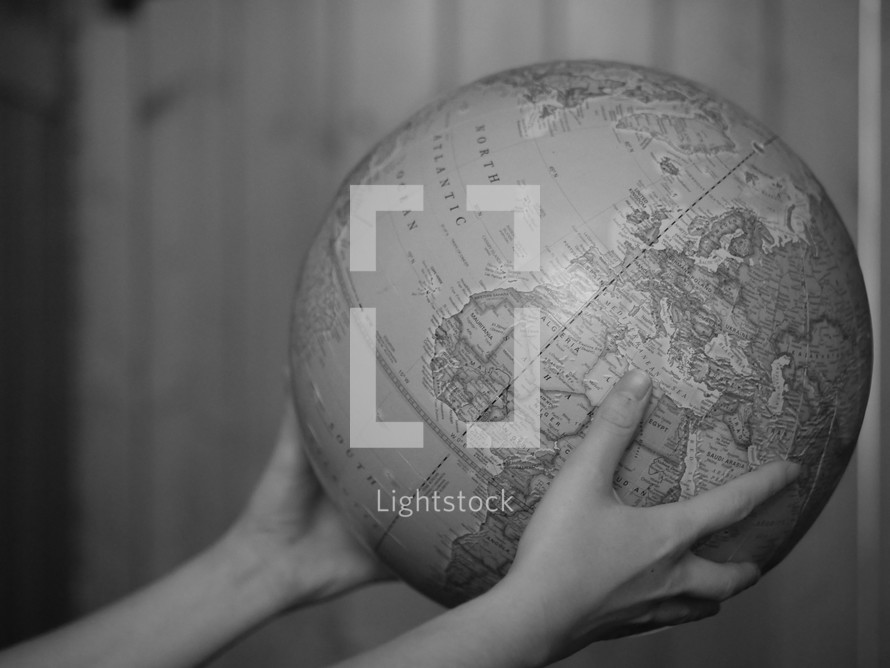 hands holding out a globe 