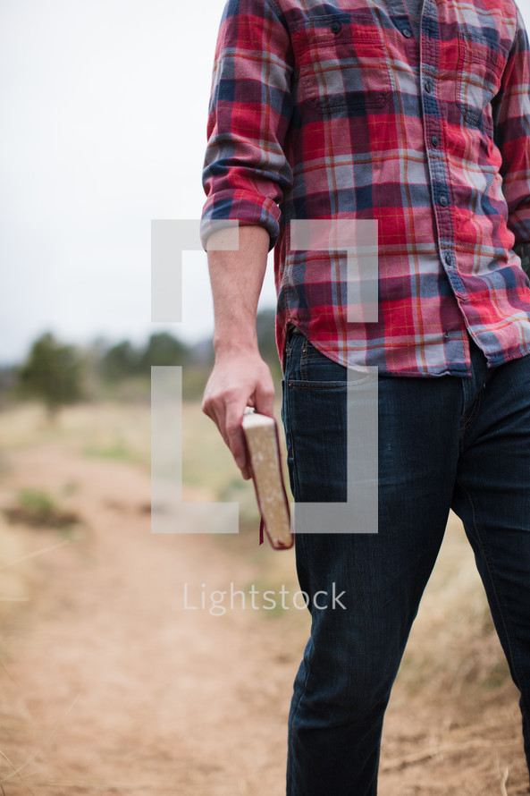 man in a plaid shirt holding a Bible 