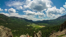 Timelapse of clouds and shadows over a valley between two mountain ranges.