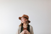 a woman in a hat holding a Bible 