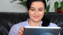 Woman on a couch using a tablet