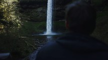man watching a waterfall 