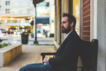 man sitting on a bench downtown 