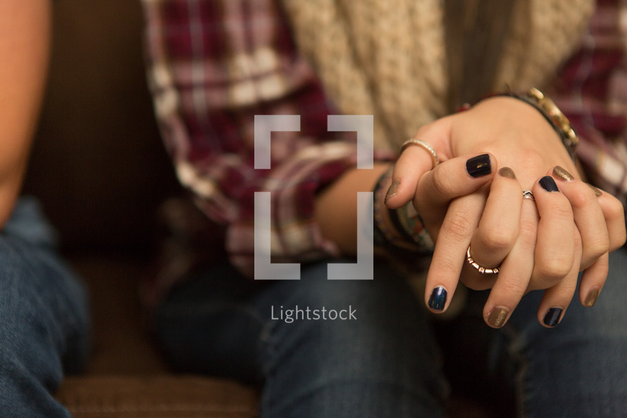 woman's fingers laced in prayer