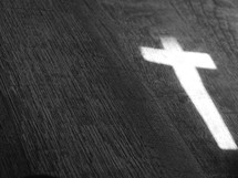 light in the shape of a cross on wood 