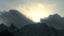 Timelapse of clouds over a snow covered mountain.