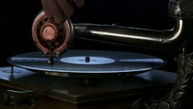 placing a needle on an antique phonographe record player