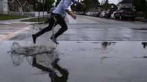 man jumping in a puddle on a rainy day 