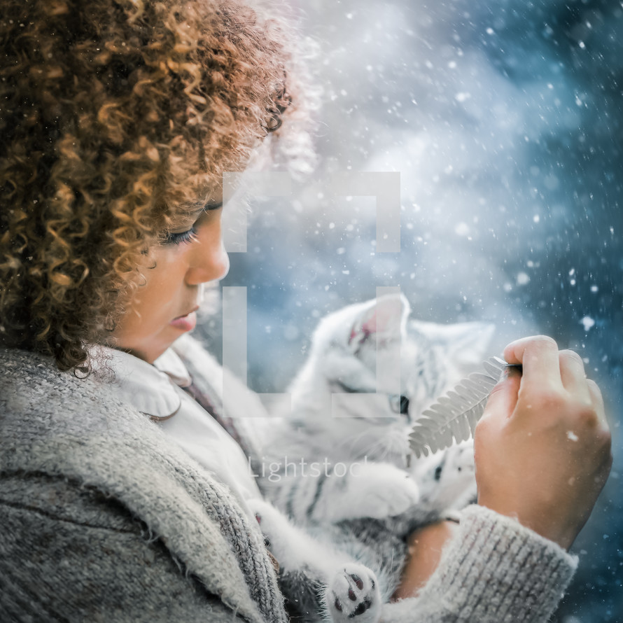 a child holding a kitten in the snow 