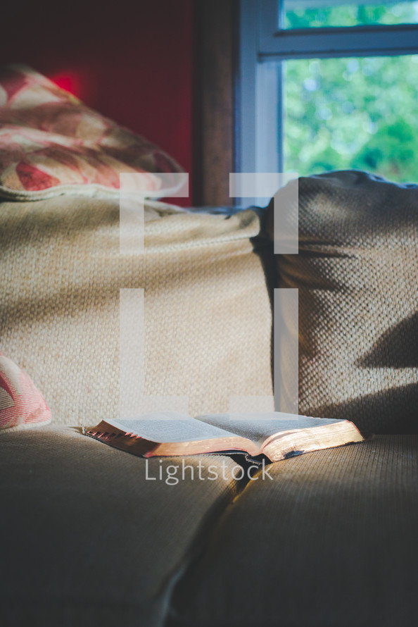 a Bible on a couch 