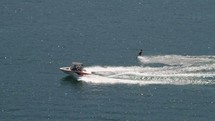 Jet boat pulling a water skier across a lake.