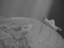 paper boat on the Atlantic Ocean on a globe 