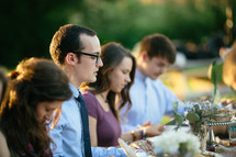 family holding hands in prayer at a dinner table