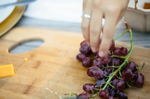 hand reaching for grapes 