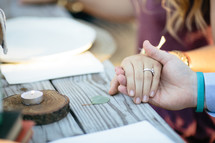 family holding hands in prayer at a dinner table